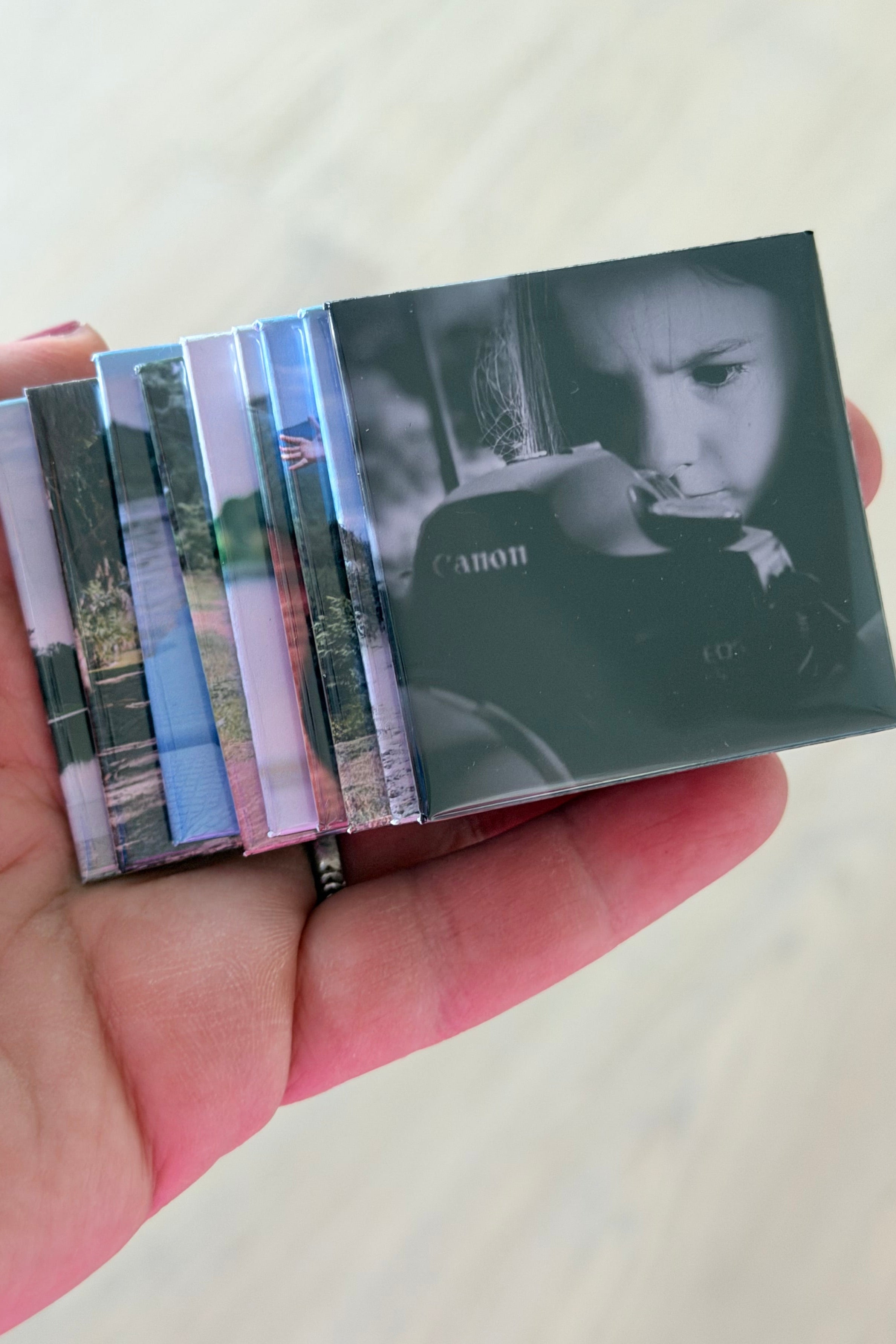Hand holding a small stack of custom square magnets.
